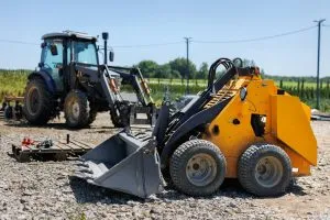 A small tractor with a bucket for moving soil, turf and bulk materials.