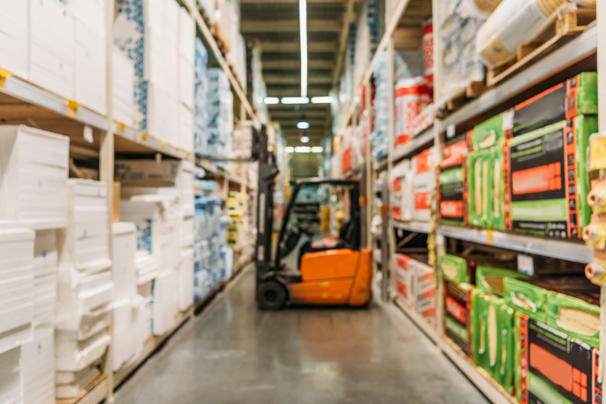 blurred view of forklift machine and shelves with boxes in storage