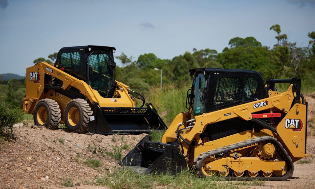 CAT construction vehicles on a dirt road.