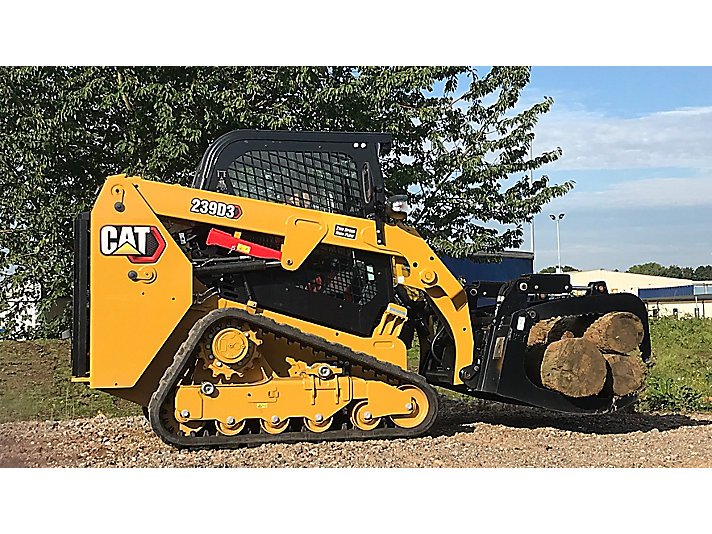 Yellow CAT skid steer loader carrying logs