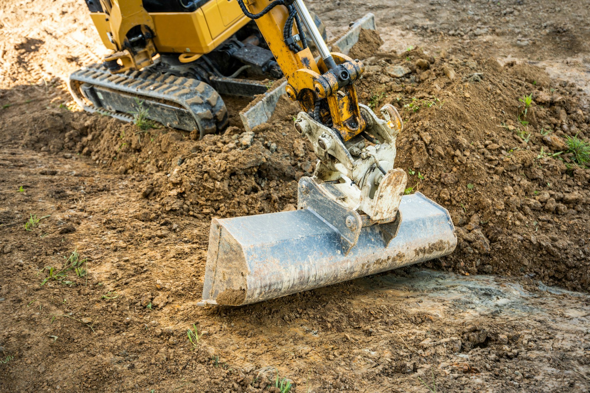 Mini excavator digging preparing ground under home garden