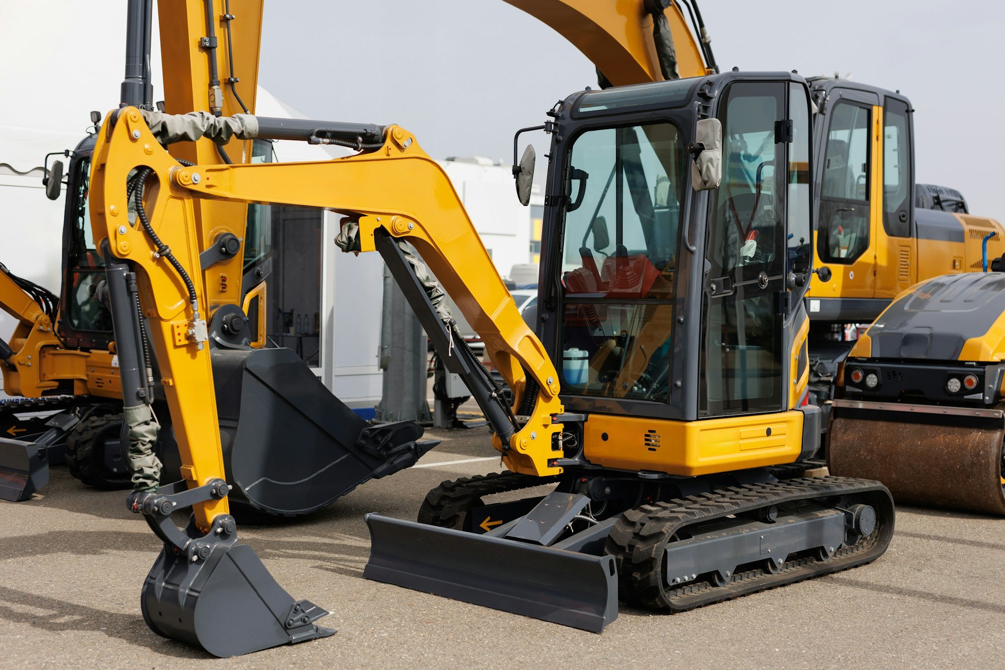 New mini excavators in the same row in the agricultural machinery store.